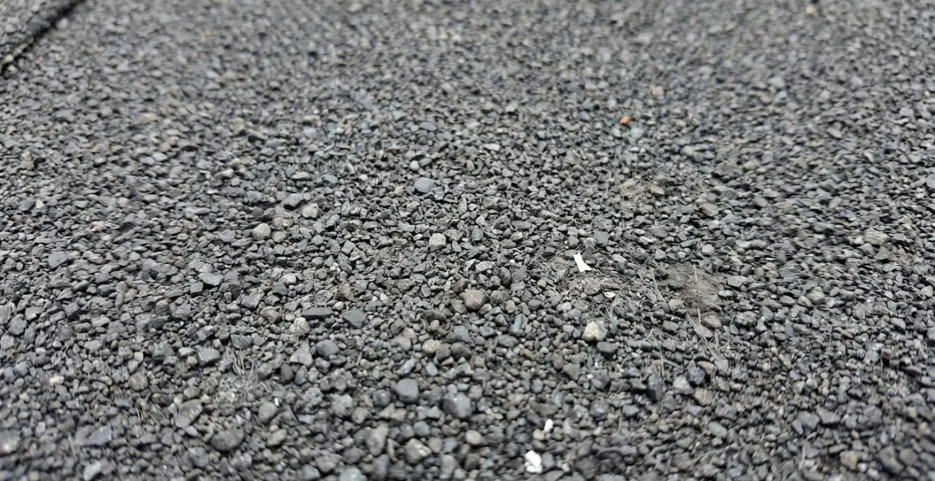 Photographie macro extrême de la surface texturée d'une membrane élastomère montrant les granules céramiques protecteurs en détail avec arrière-plan flouté